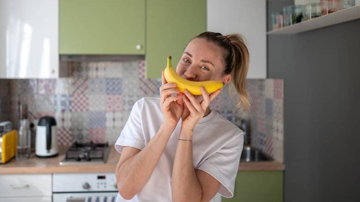 Woman holding a banana like a smiling mouth
