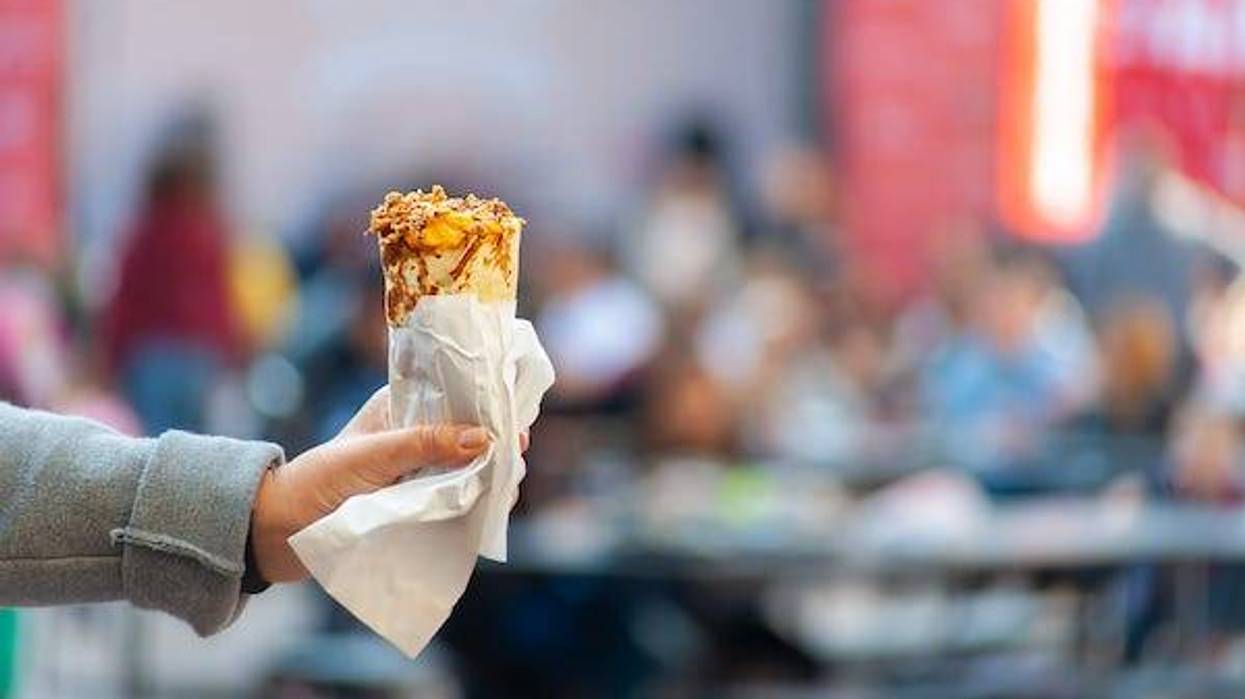 Woman holding burrito against a blurred background