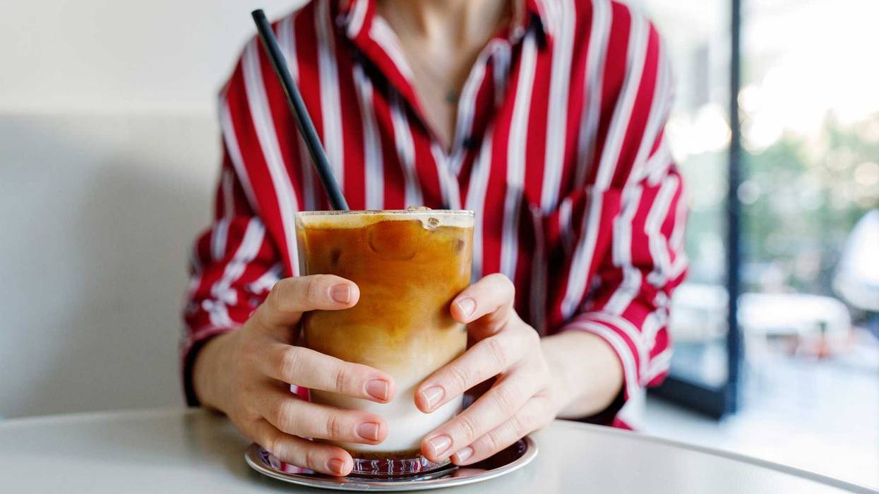 Woman holding iced pumpkin spice latte.