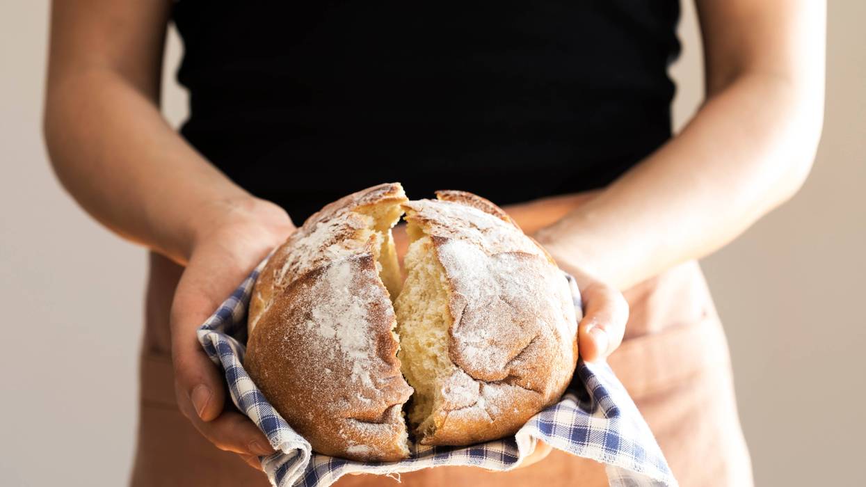 woman holding loaf of baked bread