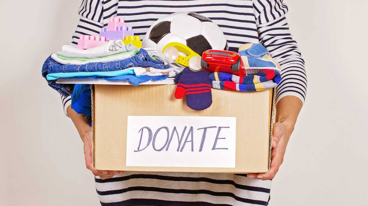 Woman holds box of toys to donate