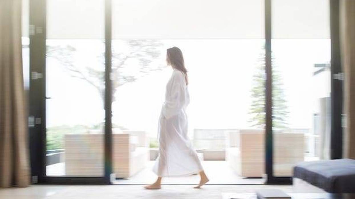 Woman in bathrobe walking through living room