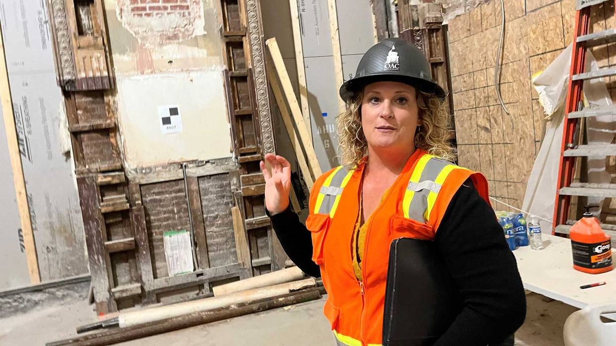 woman in orange vest and hard hat giving tour in construction zone