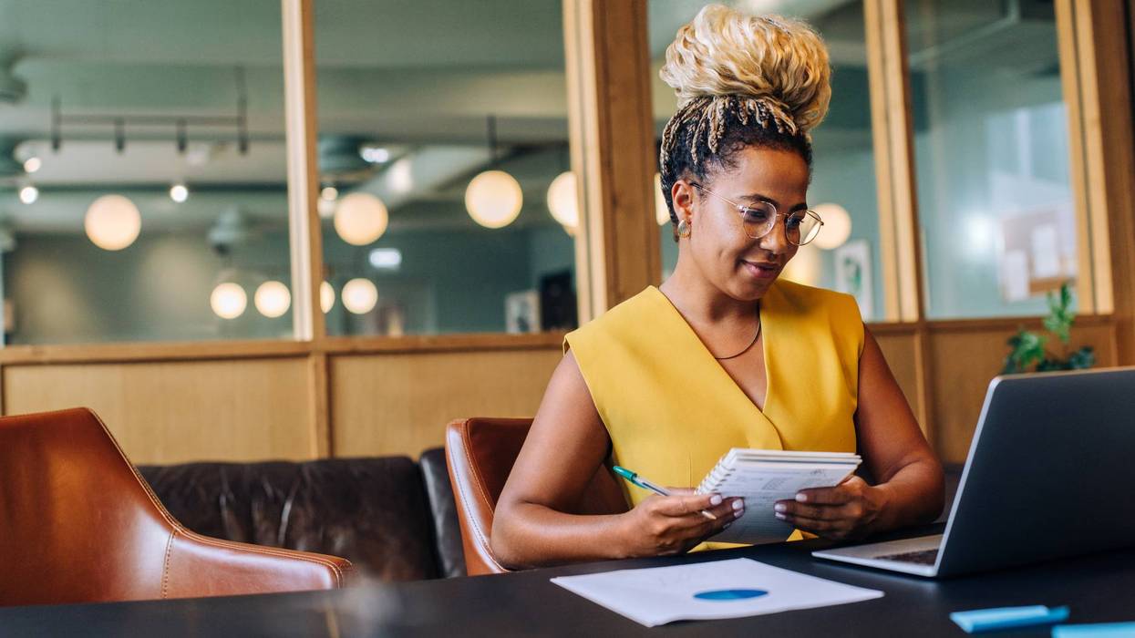 Woman in yellow working at a laptop in an open office