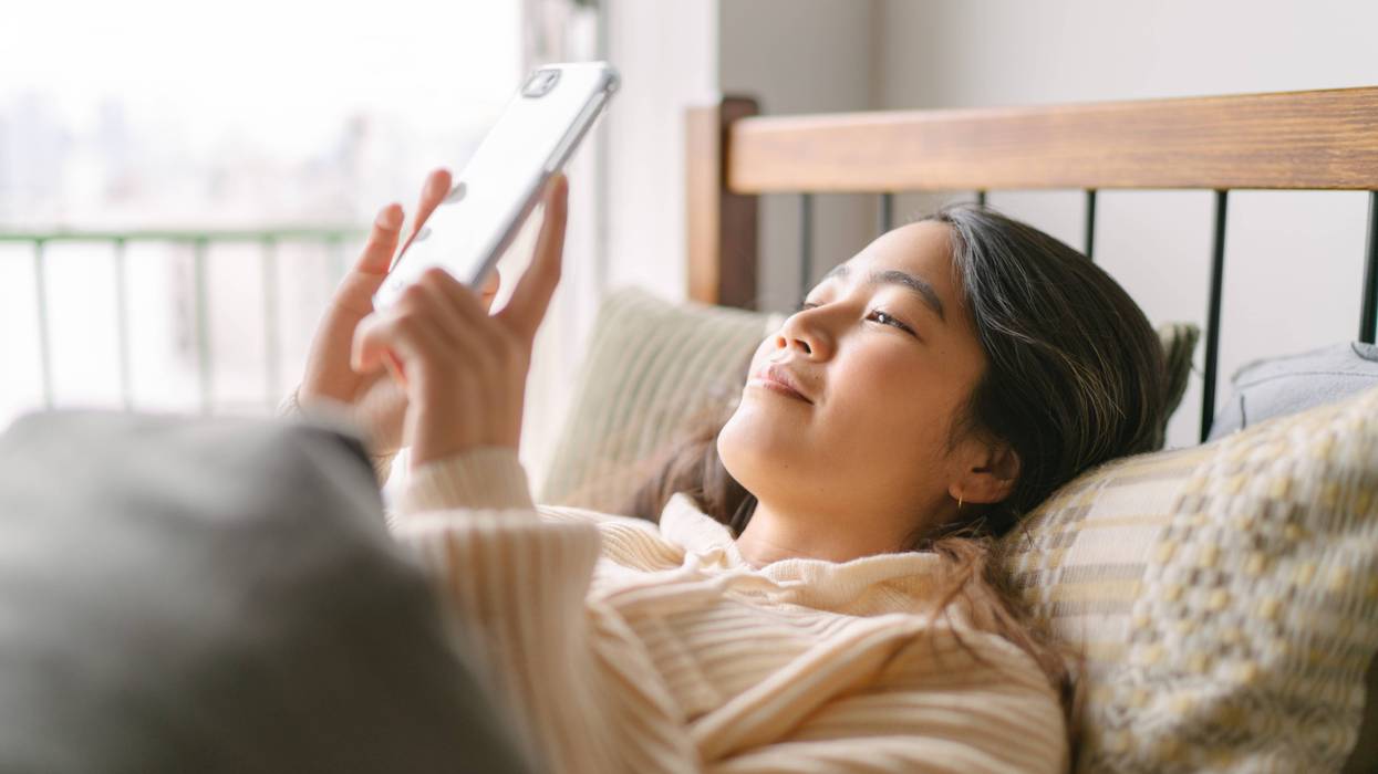 Woman laying in bed on cell phone