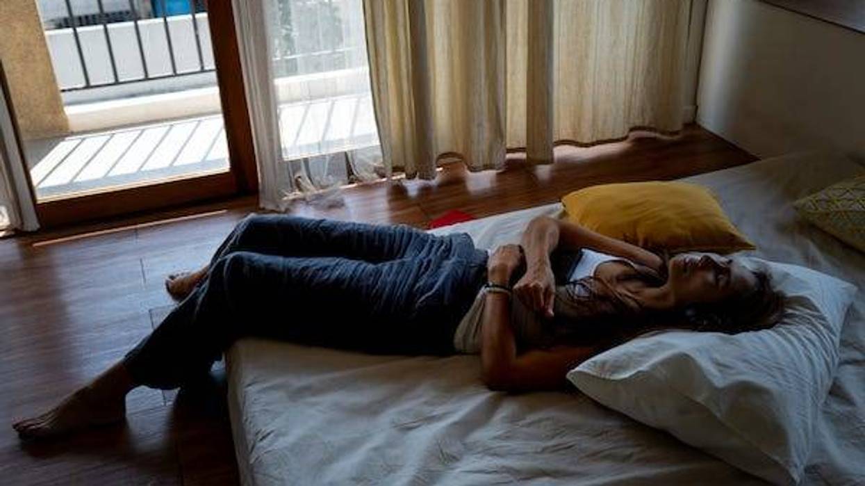 Woman laying on top of bed