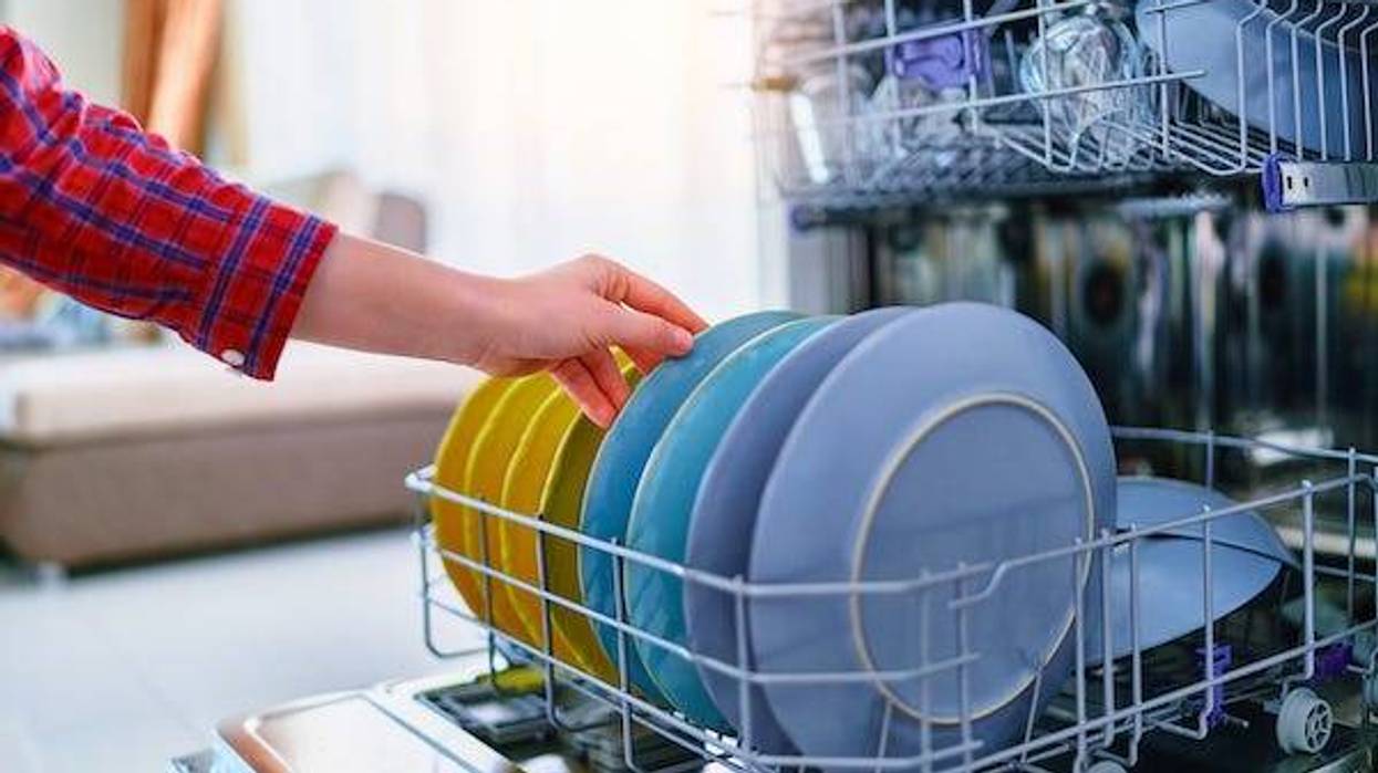 Woman loading a dishwasher in her home
