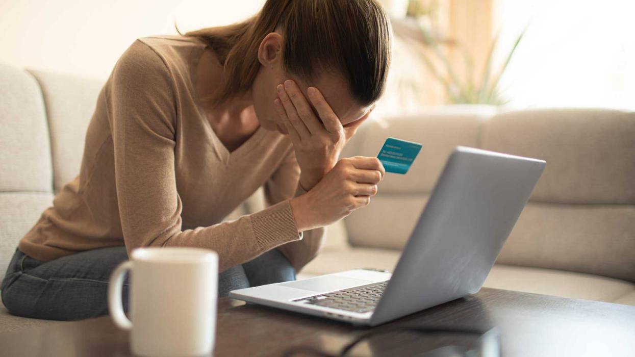 Woman looking stressed and worried with card payments and home finances accounting costs charges taxes and mortgage in paying bills financial problems and credit card debts concept.