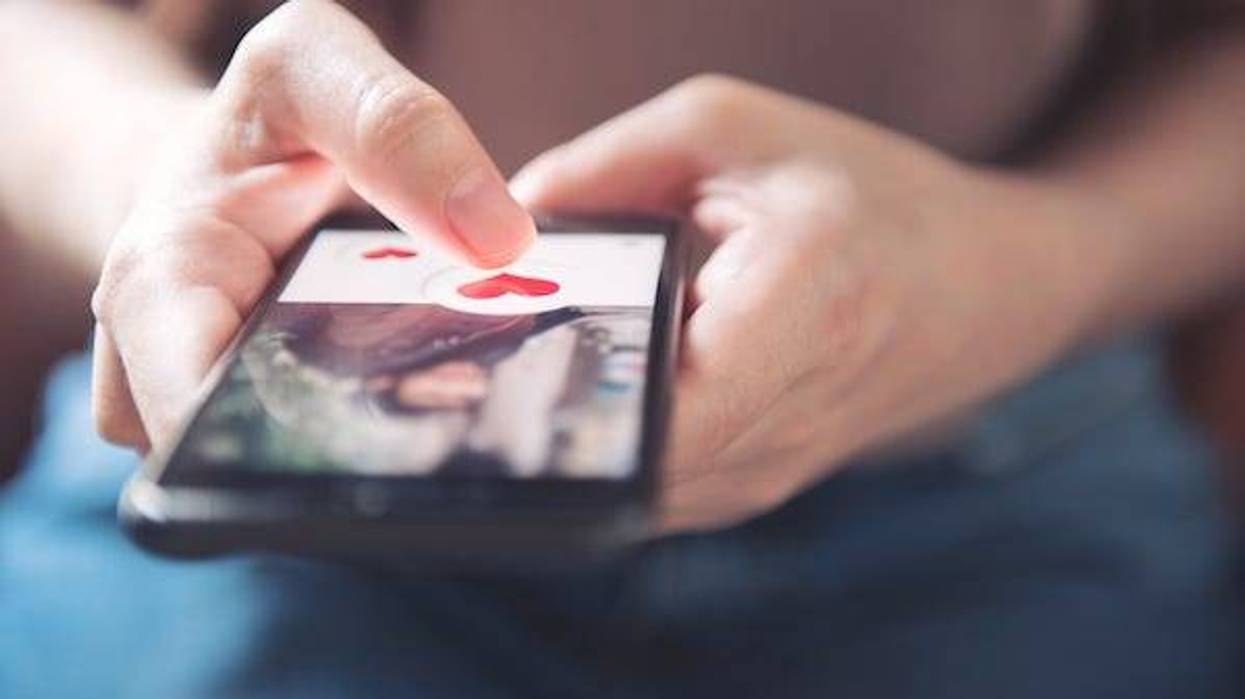 Woman pushing a heart icon on a mobile dating app