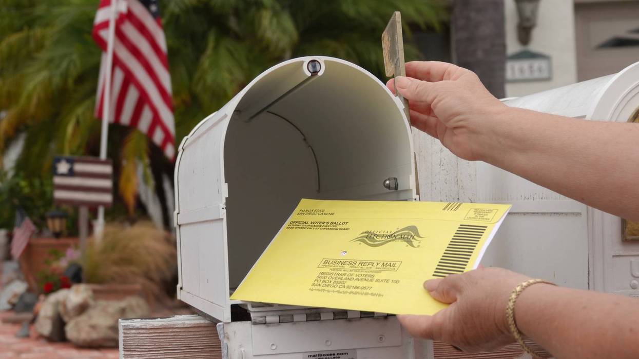 Woman puts US mail-in ballot into mailbox