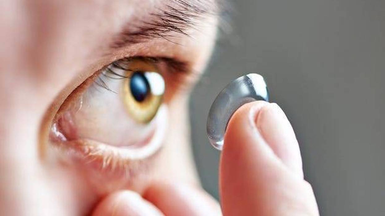 Woman putting contact lens into eye
