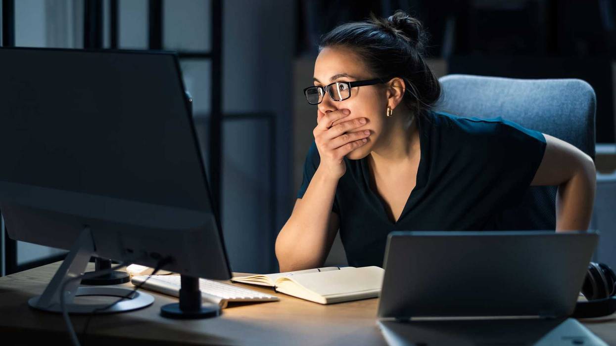 Woman shocked at computer screen stock photo.