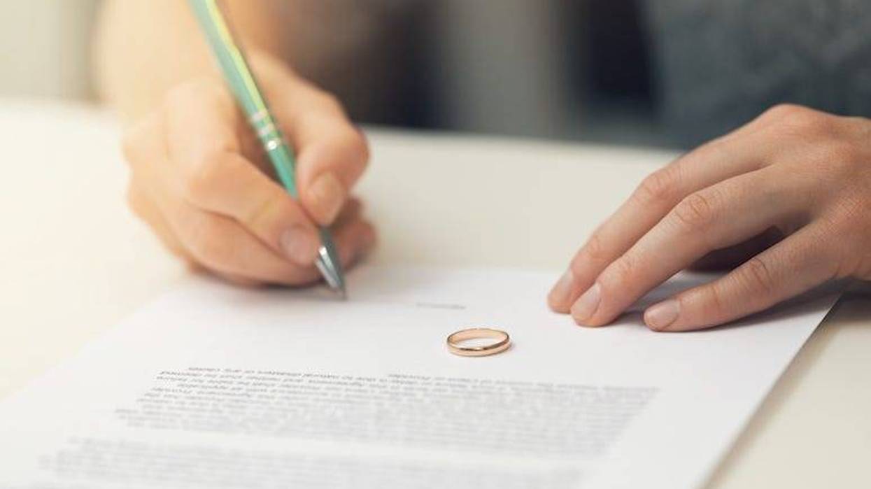 Woman signing document with wedding ring