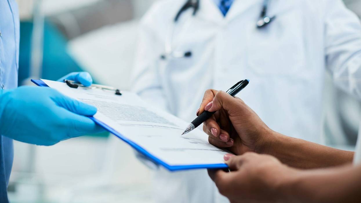 Woman signing paperwork during medical appointment at clinic.