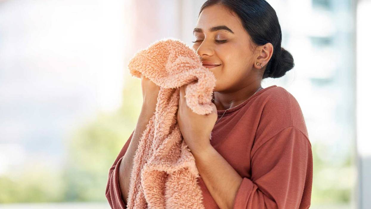 Woman smelling a piece of laundry.