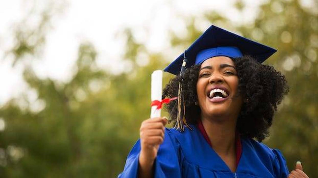 Woman smiling holding degree after graduation