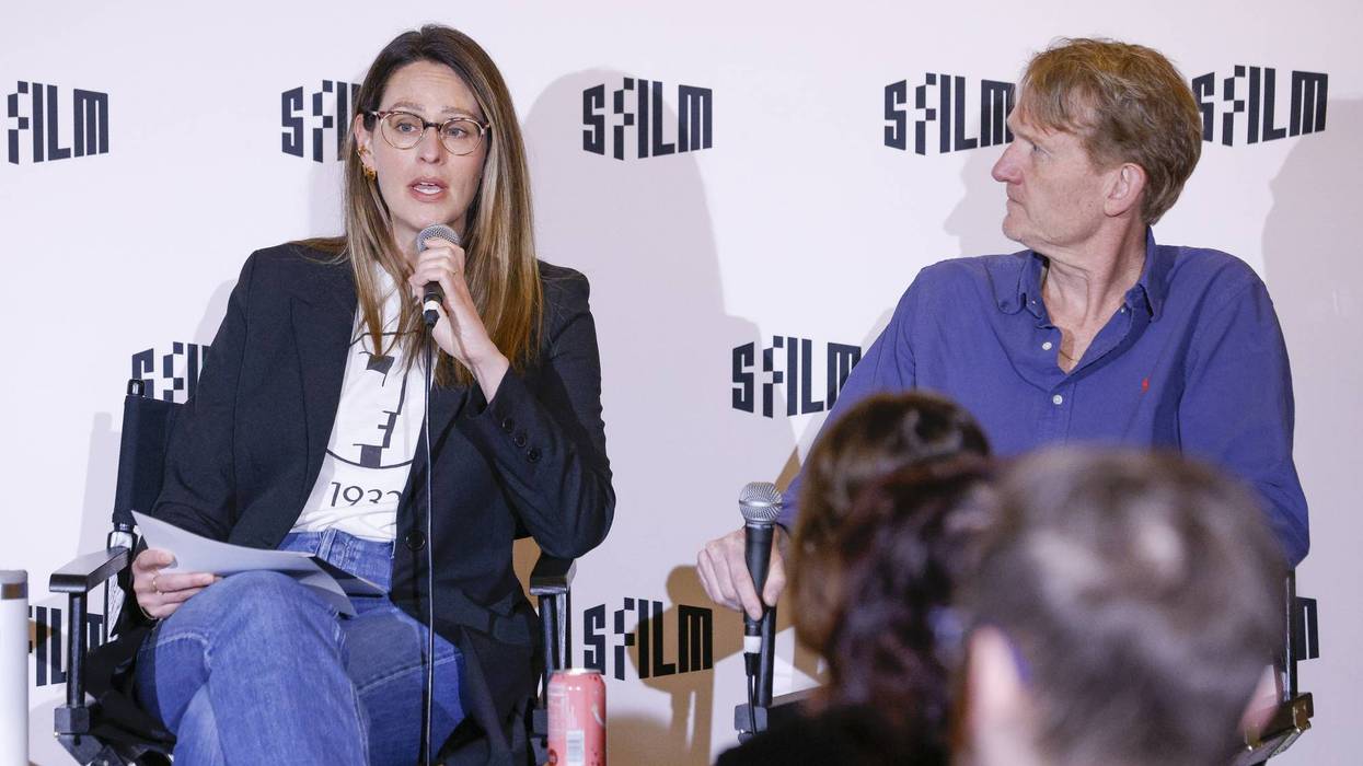 Woman speaking into mic, man listening at SFFILM event.