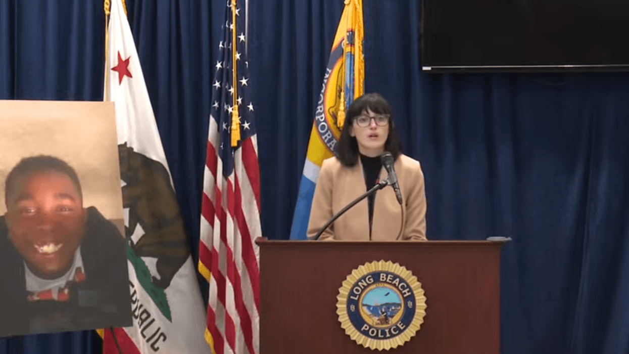 woman speaks at podium next to photo of child