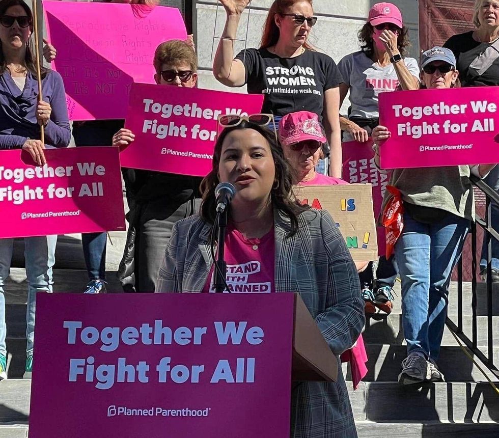 Woman standing at podium at abortions rights rally
