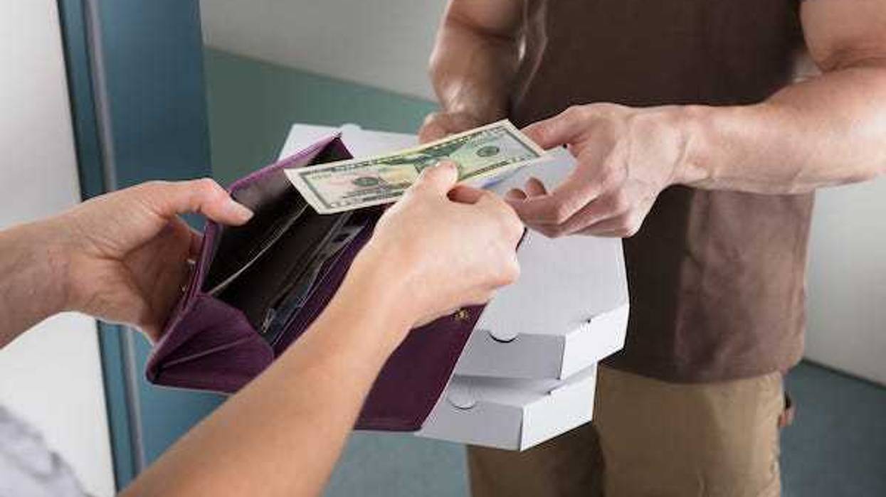 Woman tipping delivery man