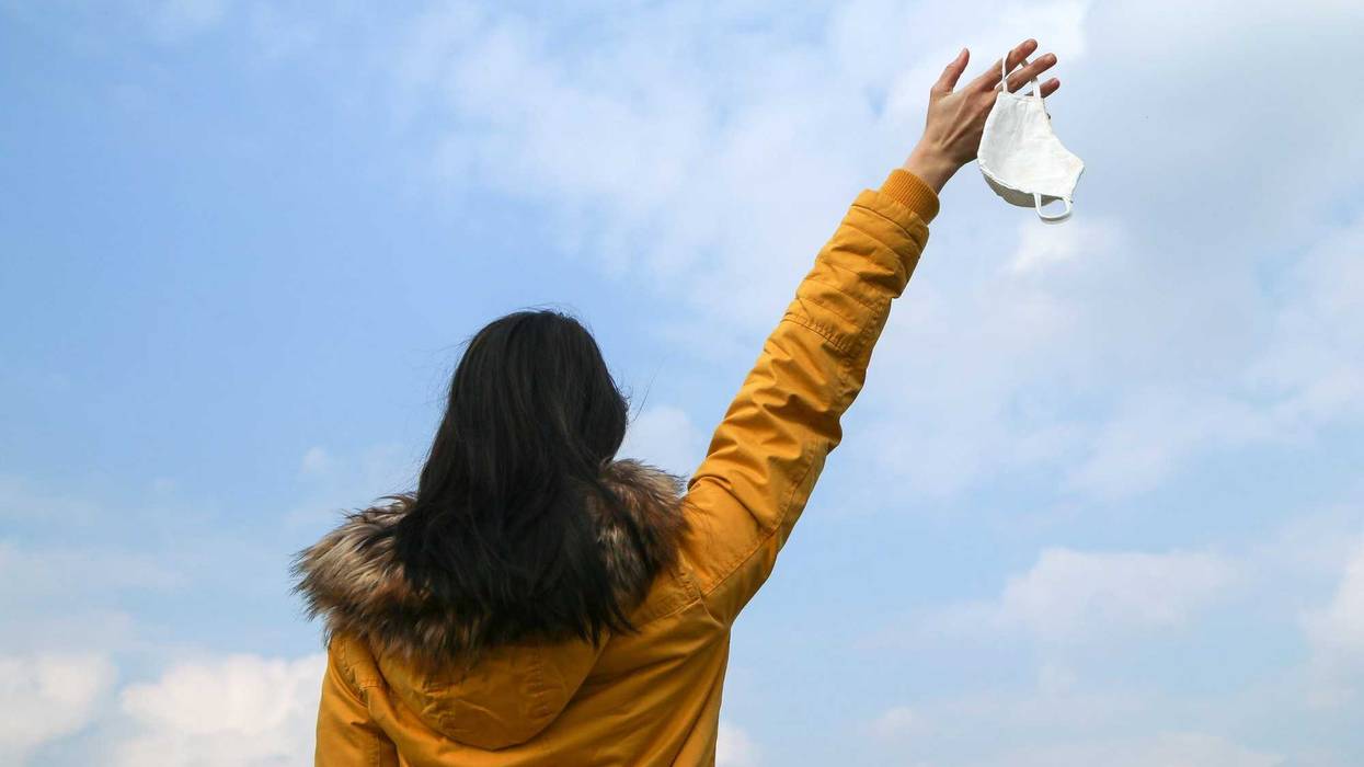 Woman tossing mask stock photo.