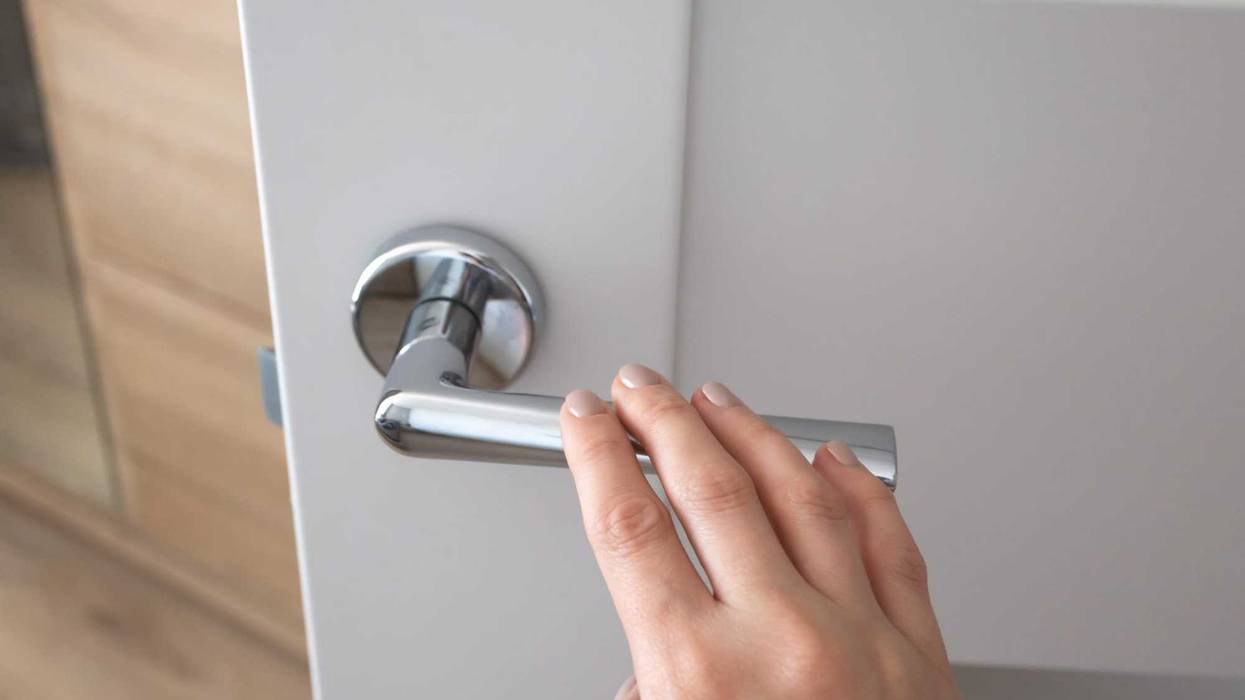 Woman touching door handle stock photo?