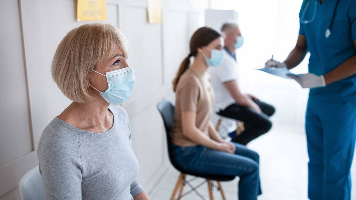 Woman waiting for COVID-19 vaccine shot stock photo.