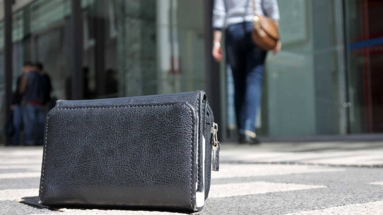 Woman walking away after losing her wallet on city street. loss concept. Real people. Copy space