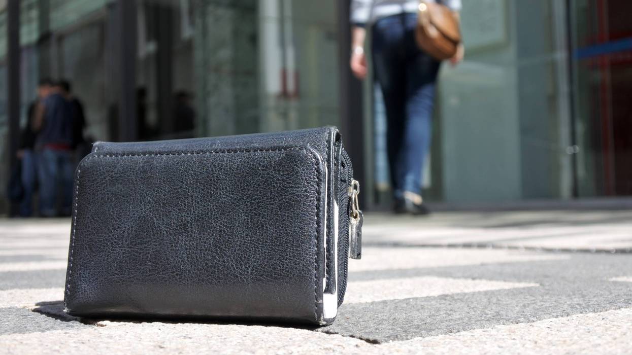 Woman walking away after losing her wallet on city street. loss concept. Real people. Copy space