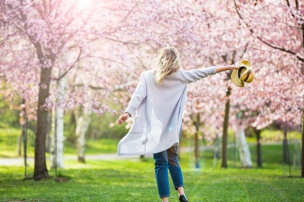 Woman walking through flowering trees