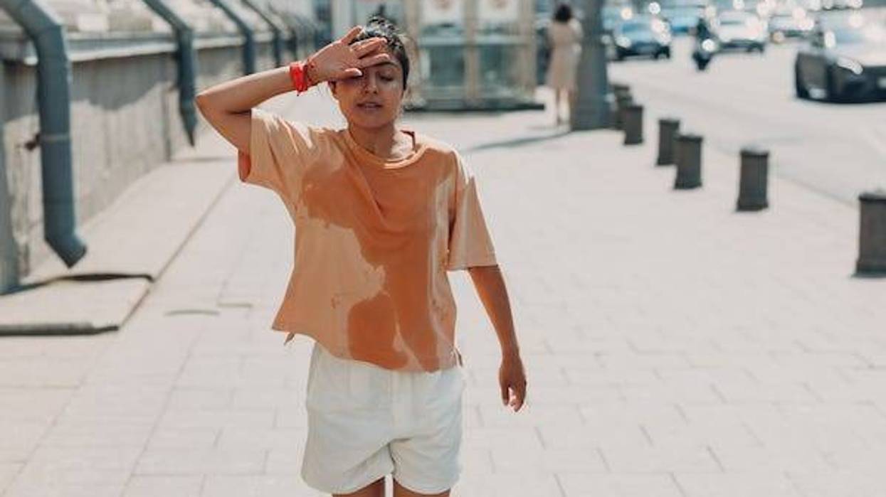 Woman wearing a sweaty shirt while walking down the street