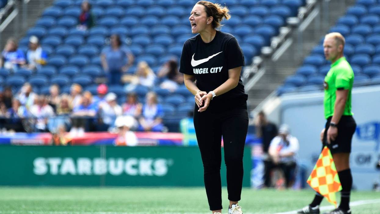 woman wearing angel city t-shirt on sidelines of soccer field