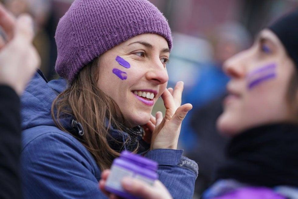 Woman wears purple face paint while participating in the "Purple Ride" feminist women