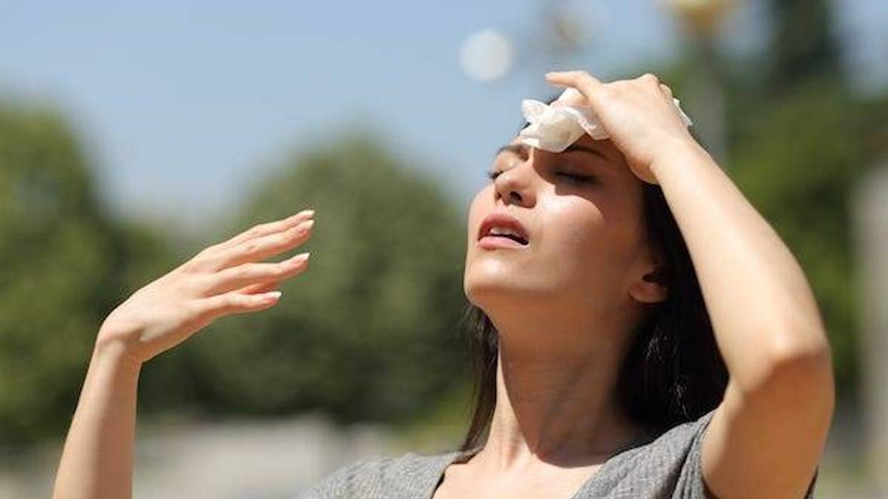 Woman wiping her brow on a hot, summer day