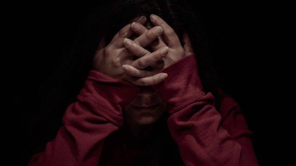 Woman With Head In Hands In Darkroom