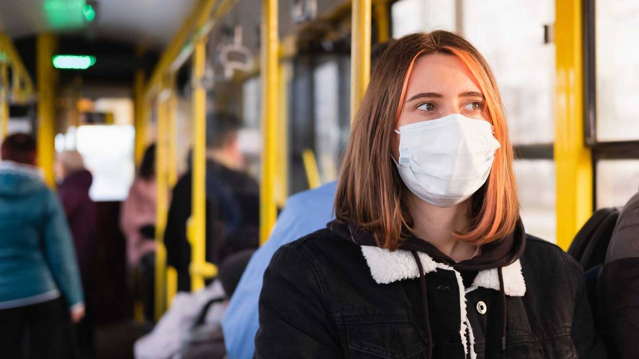 Woman with mask on bus stock photo.