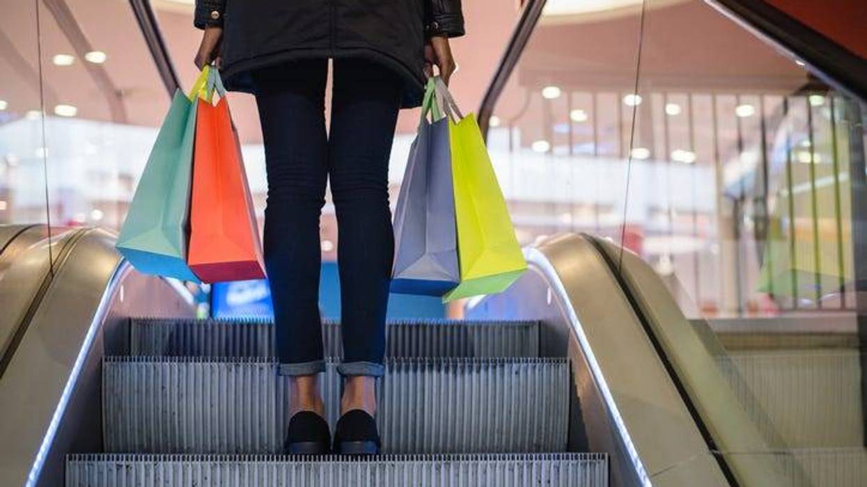 woman with shopping bags on a mall escalator
