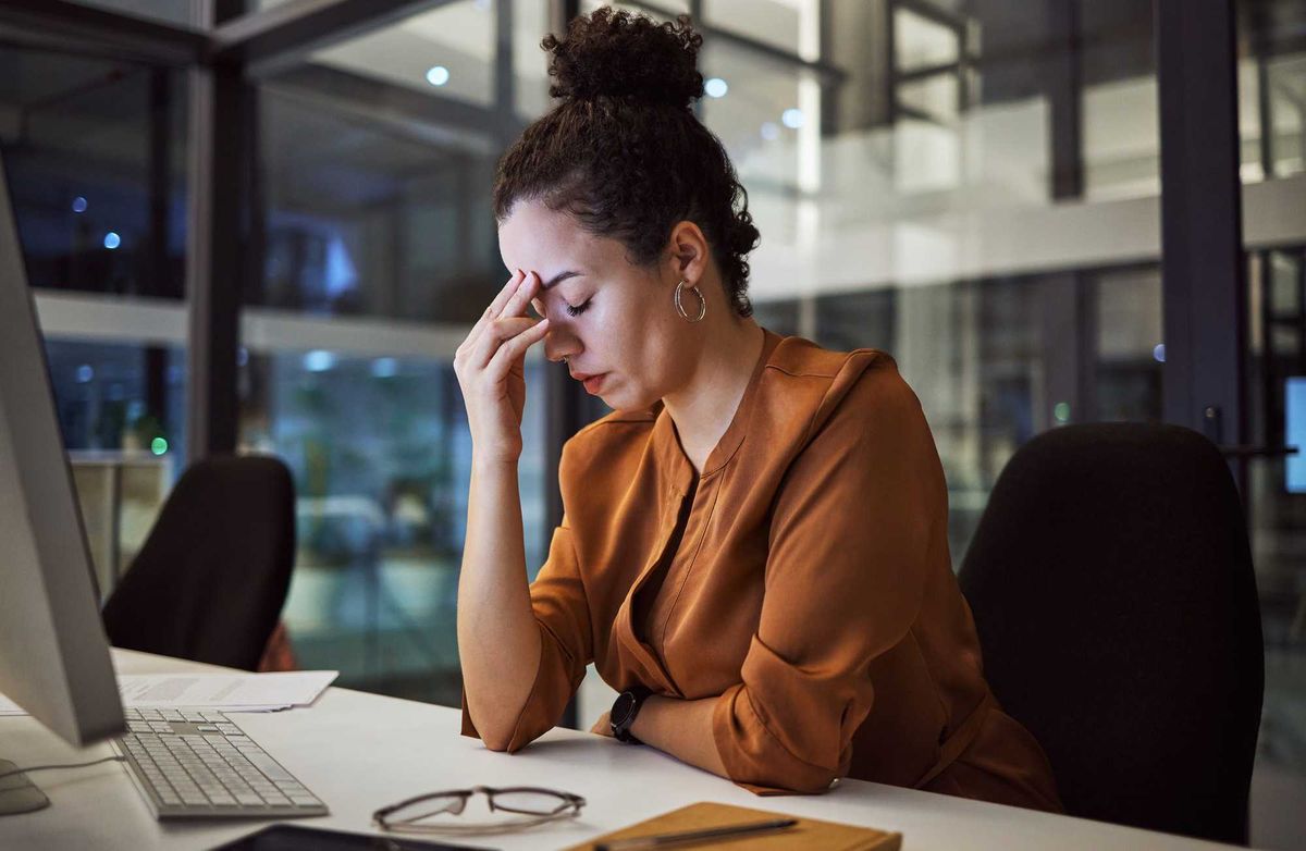 Woman working at night with headache.