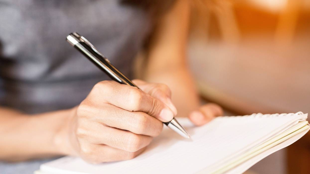 Women holding a pens writing a notebook. Recording concept
