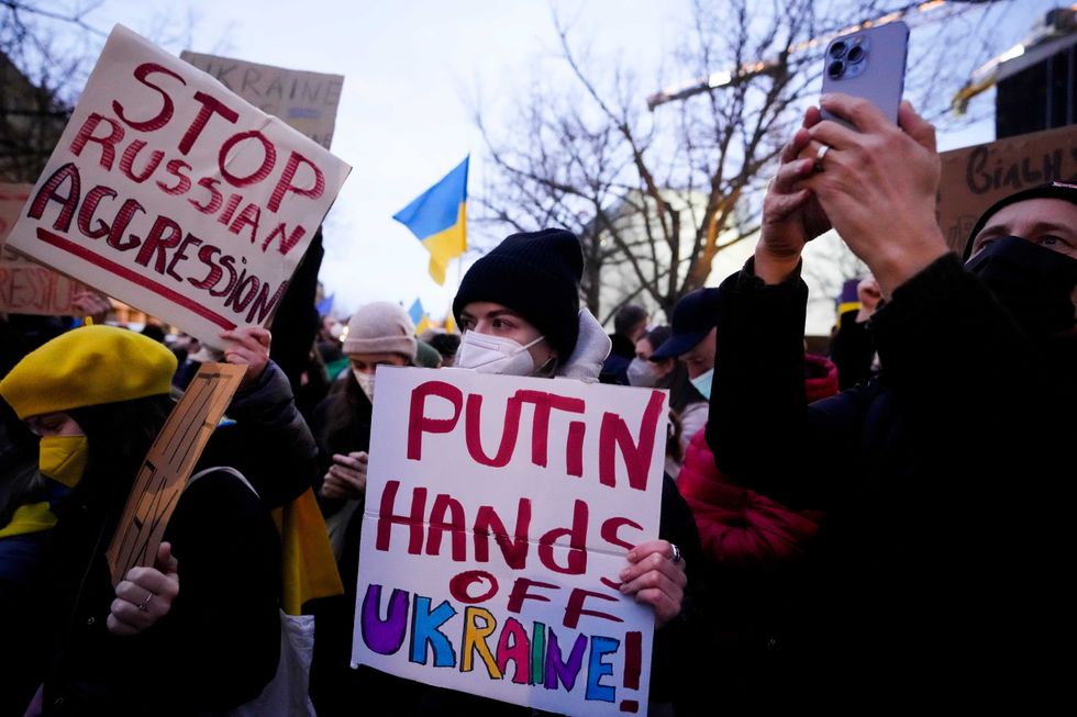 Women show posters in support of the Ukraine as they attend a demonstration along the street near the Russian embassy to protest against the escalation of the tension between Russia and Ukraine in Berlin, Germany, Tuesday, Feb. 22, 2022
