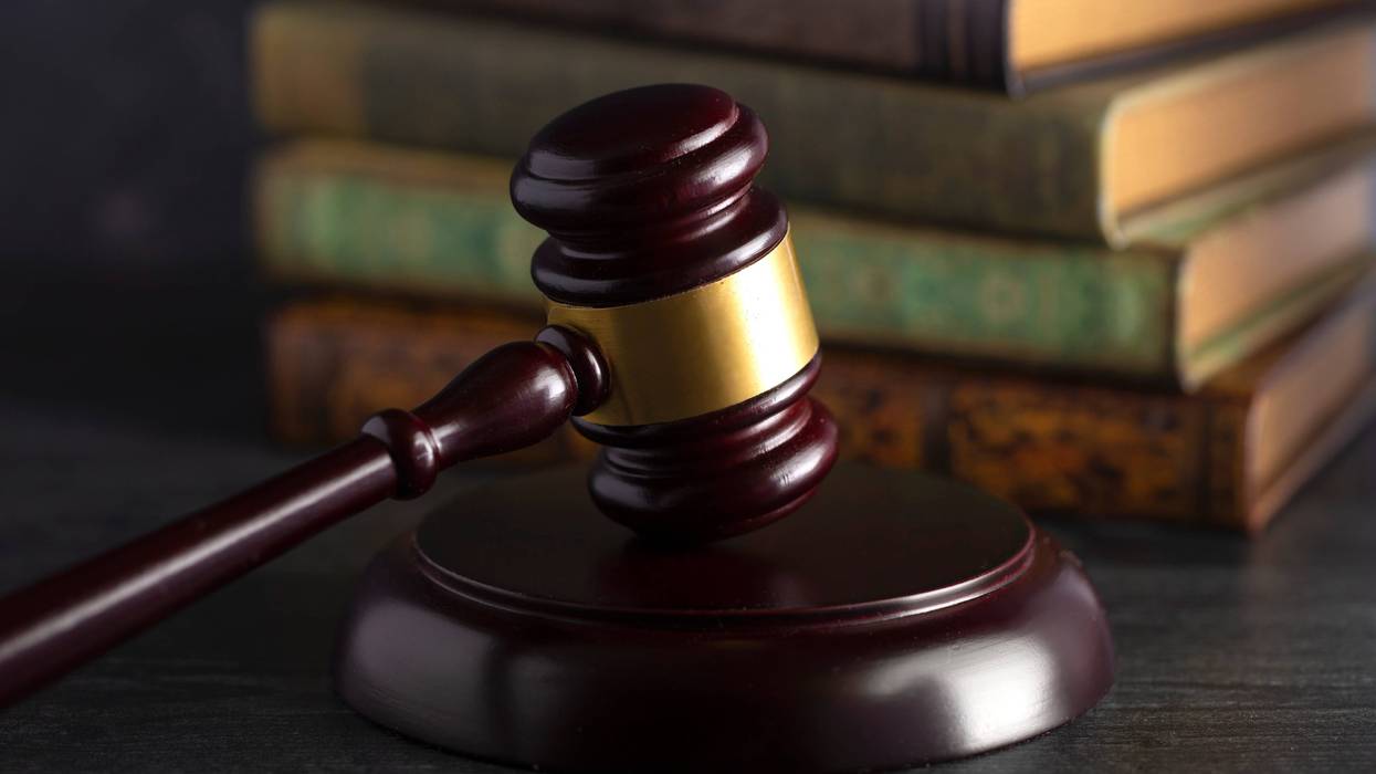 Wooden judges gavel on a desk with books in the background