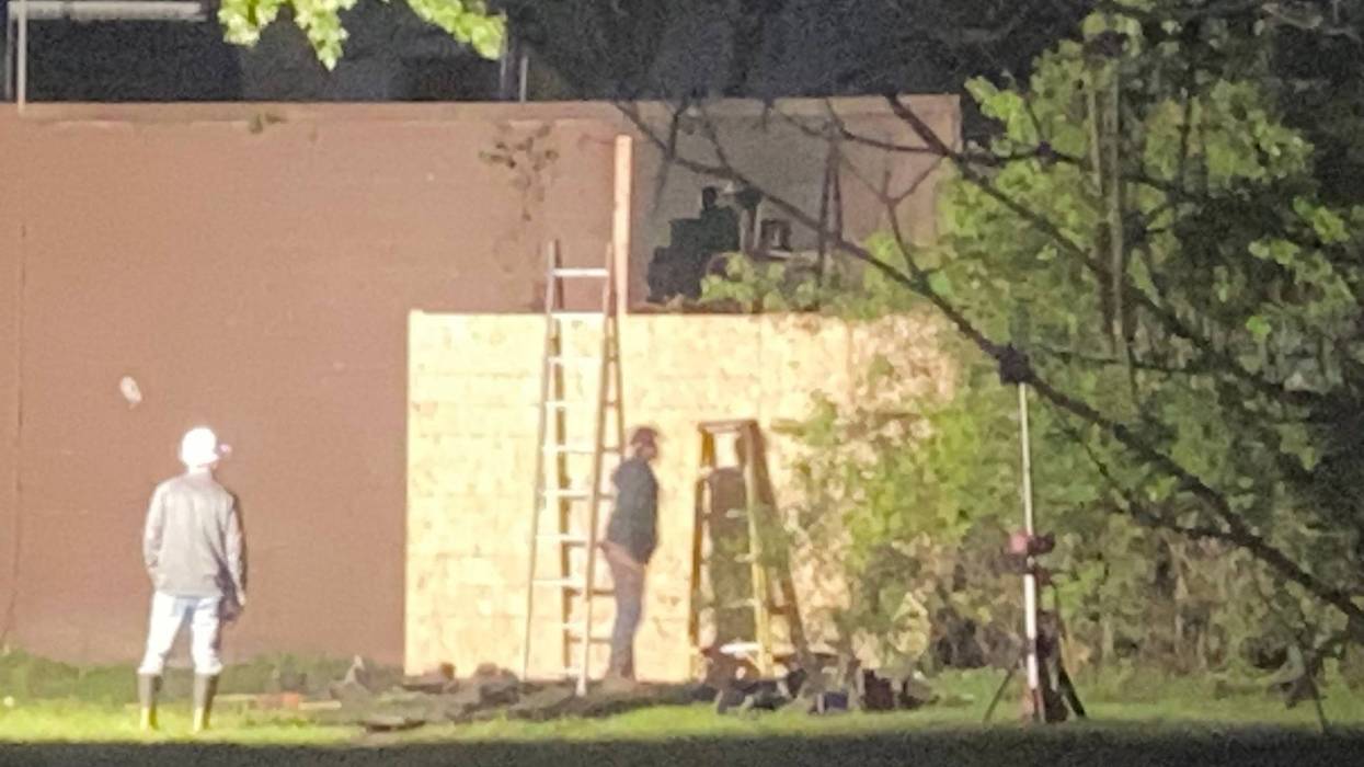 Workers board up a building after a car crashed into it in Southfield on Wednesday.