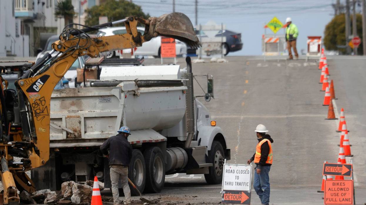 Workers dig a hole in the street as they make infrastructure repairs on April 07, 2021 in San Francisco, California.