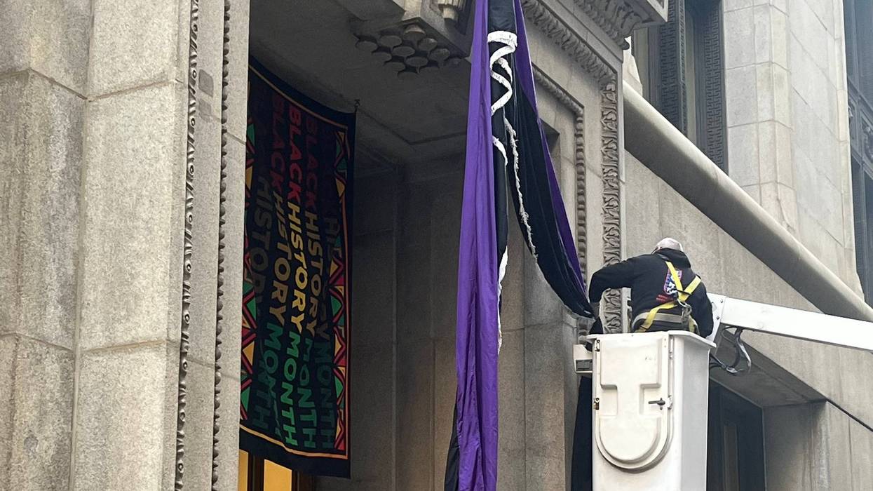 Workers drape bunting over the LaSalle Street entrance to Chicago City Hall in honor of the late Rev. Jesse Jackson.