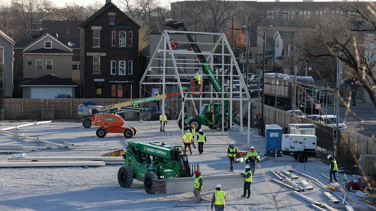 Workers erect a tent frame.