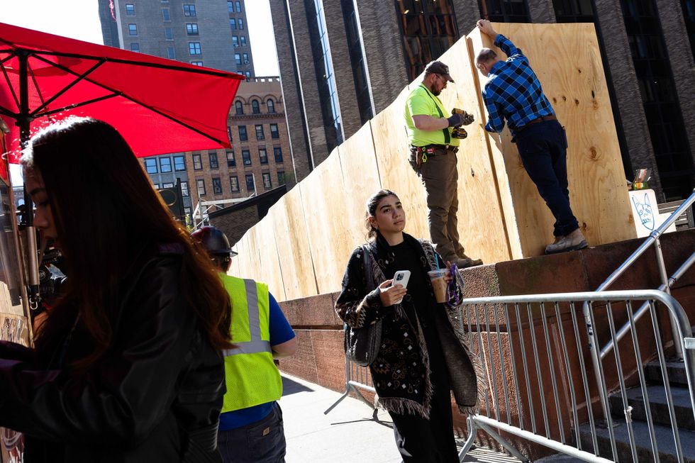 Workers erect a wooden wall at Gould Plaza at New York University Stern School of Business on April 23, 2024, after an encampment set up by NYU students was cleared out