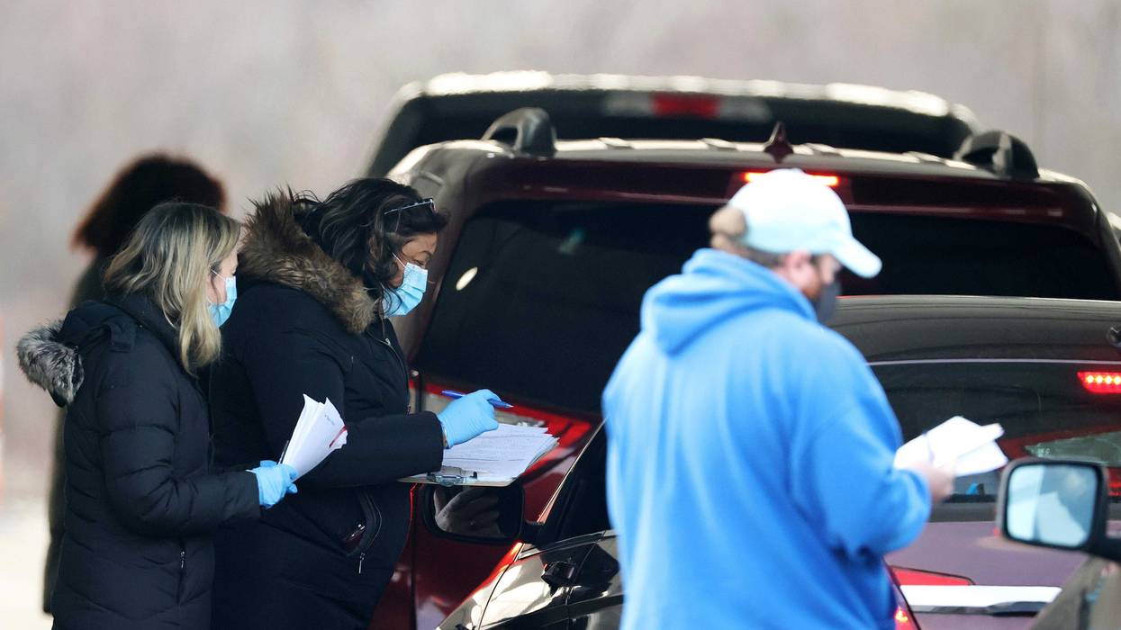 Workers help to facilitate arrivals at a drive-through COVID-19 vaccination site at Jones Beach State Park on January 14, 2021 in Wantagh, New York.