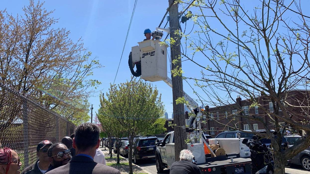 Workers install security cameras outside the perimeter of Dendy Recreation Center in North Philadelphia.