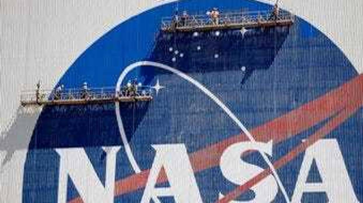 Workers near the top of the 526 ft. Vehicle Assembly Building at the Kennedy Space Center spruce up the NASA logo standing on scaffolds in Cape Canaveral, Fla., Wednesday, May 20, 2020. (AP Photo/John Raoux)