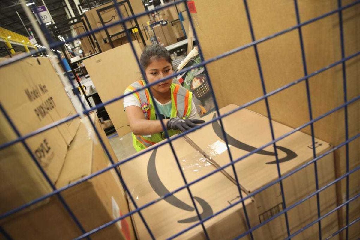 Workers pack and ship customer orders at an Amazon fulfillment center.